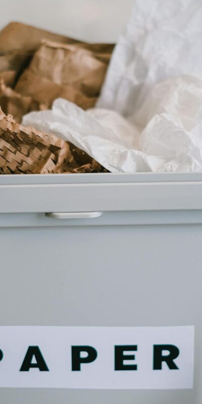 Closeup of plastic container full of paper placed on blurred background of kitchen in daytime